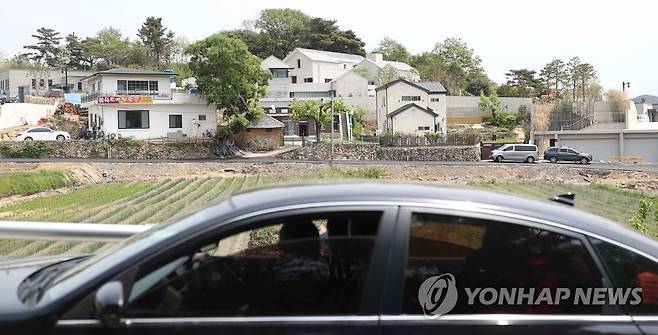 사저 구경 (양산=연합뉴스) 김동민 기자 = 문재인 대통령 내외 귀향을 이틀 앞둔 8일 문 대통령 사저가 위치한 경남 양산시 하북면 평산마을에서 차량에 탑승한 시민이 사저를 바라보고 있다. 2022.5.8 image@yna.co.kr