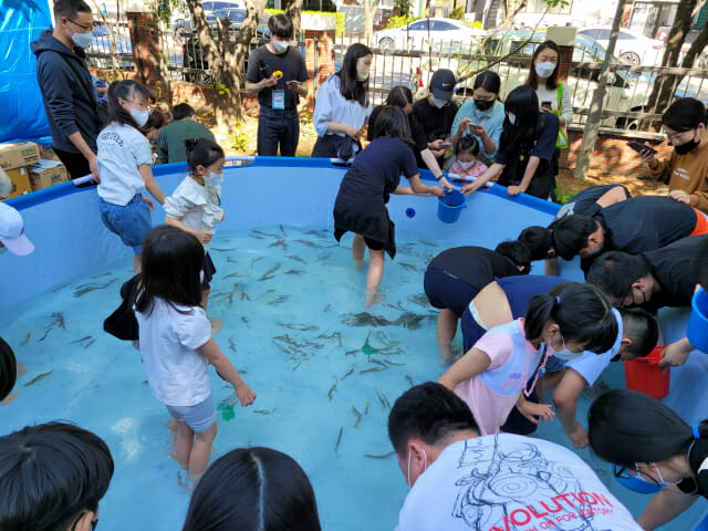 GS파워와 삼정종합사회복지관이 공동주최한 마을축제에서 아이들이 미꾸라지잡기 놀이를 하고 있다.