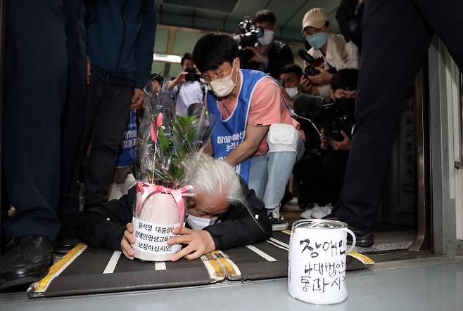 박경석 전국장애인차별철폐연대 공동대표가 10일 오전 서울 지하철 5호선 광화문역에서 윤석열 대통령 취임식날에 맞춰 ‘장애인 권리 예산 보장’ 등을 촉구하며 기어서 지하철에 탑승하는 ‘오체투지’ 시위를 하고 있다.(사진=뉴스1)