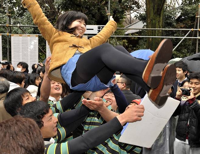 학생들이 도쿄대에 합격한 한 여학생을 헹가래치고 있다. /ⓒ AFP=뉴스1