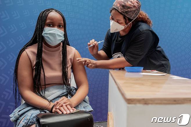 15일(현지시간) 남아프리카공화국 수도 요하네스버그에서 한 여성이 신종 코로나바이러스 감염증(코로나19) 백신 화이자를 접종하고 있다. 2021.12.15 © AFP=뉴스1 © News1 정윤미 기자