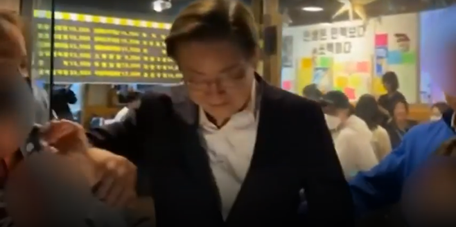 이재명 더불어민주당 총괄선거대책위원장이 11일 인천 계양구 동양동 일대 상가에서 주민 인사를 진행하던 도중, 즉석 연설을 위해 단상으로 오르면서 방금전 기념촬영을 했던 한 여자 아이를 밀어내는 듯한 동작을 취하고 있다. ⓒ유튜브 캡쳐