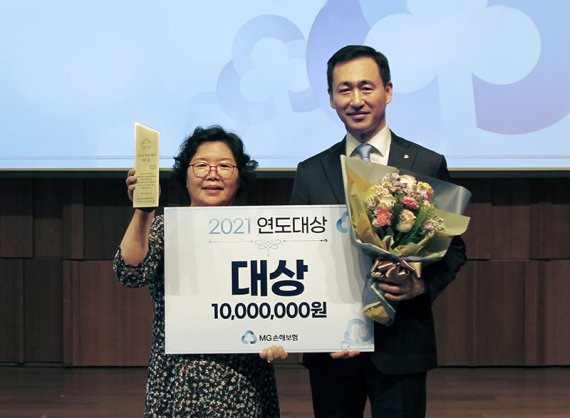 MG손해보험 오승원 대표(오른쪽)가 지난 11일 서울 중구 신라호텔에서 '2021 연도대상 시상식'을 진행한 후 대상을 수상한 김길연RC와 기념촬영을 하고 있다. MG손해보험 제공