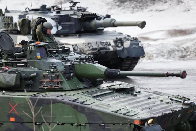 러시아의 우크라이나 침공 전쟁이 한창인 지난 3월 22일(현지시간) 노르웨이에서 펼쳐진 북대서양조약기구(NATO·나토) 연합훈련 '콜드 리스펀스'(Cold Response 2022)에서 핀란드와 스웨덴군 탱크가 보인다. 이브네스=로이터 연합뉴스
