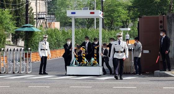 12일 오전 서울 용산구 이촌역 인근 대통령실 출입구에서 직원들이 윤석열 대통령 출근에 앞서 교통 수신호 시설을 도로로 옮기고 있다. 연합뉴스