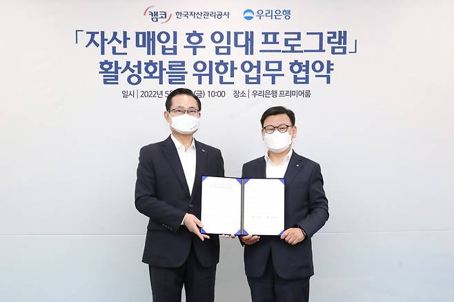 이원덕 우리은행장(오른쪽)과 권남주 한국자산관리공사 사장이 13일 서울 중구 우리은행 본점에서 기념촬영을 하고 있다. /우리은행 제공
