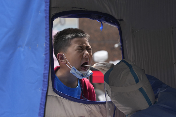 중국 베이징의 한 코로나19 검사소에서 어린아이가 눈을 질끈 감은 채 검사를 받고 있다. 베이징에선 코로나19 확산세가 지속되면서 사실상 봉쇄식 관리가 이뤄지는 관리통제구역의 범위가 확대되고 있다. AP연합뉴스