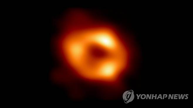 사상 최초 우리 은하 중심 블랙홀 포착 (서울=연합뉴스) 한국천문연구원이 참여한 '사건지평선망원경'(EHT) 협력단이 사상 최초로 우리은하 중심에 위치한 초대질량 블랙홀 궁수자리(Sgr A*)를 포착해 12일 공개했다.
사진은 관측된 궁수자리 A 블랙홀 이미지. 중심의 검은 부분은 블랙홀과 블랙홀을 포함하는 그림자이고, 고리의 빛나는 부분은 블랙홀의 중력에 의해 휘어진 빛이다. 2022.5.12 [한국천문연구원·EHT 제공. 재판매 및 DB 금지] photo@yna.co.kr