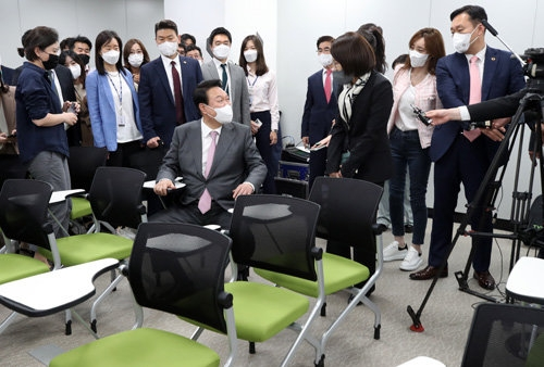 윤석열 대통령이 13일 용산 대통령실 청사 기자실을 둘러보다 기자회견장 기자석에 앉아 강인선 대변인과 대화를 나누고 있다. 대통령실사진기자단