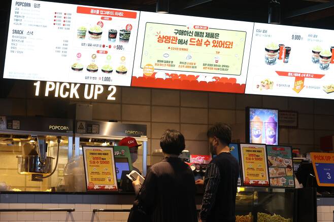 영화관 내 취식 금지가 해제된 지난달 25일 서울 용산구 CGV용산아이파크몰에서 관객이 팝콘 등을 구매하고 있다. /연합뉴스