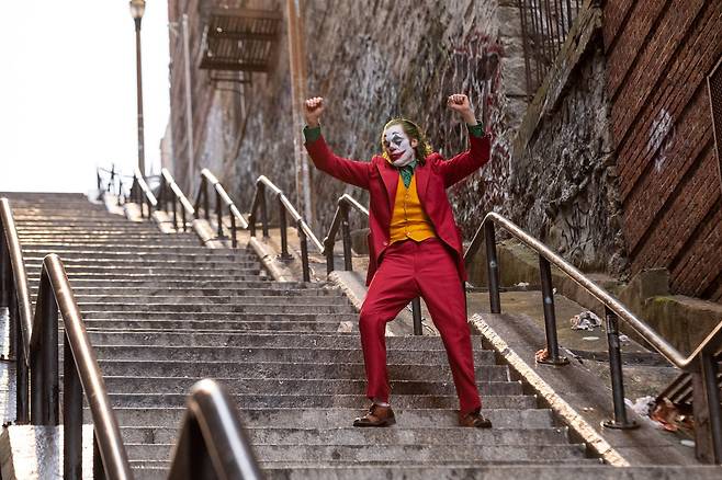 영화 ‘조커’에서 주인공 아서가 광기에 젖어 계단을 내려가며 춤추는 모습. /워너브라더스코리아
