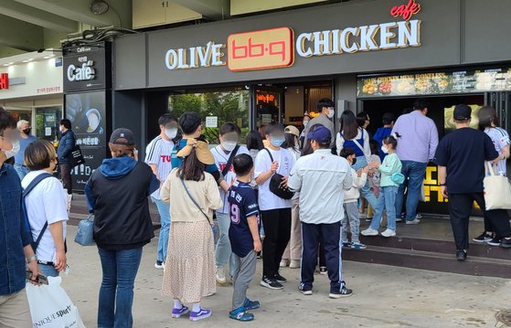 지난달 30일 서울 잠실야구장을 찾은 가족 단위 야구팬들이 치킨 구입을 위해 BBQ 잠실야구장점 앞에 줄 서 있다. 이 회사는 이달 초 치킨값은 인상했다. 뉴스1