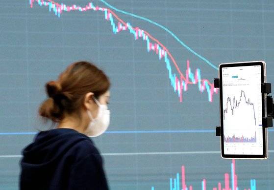 최근 일주일 99.99% 하락하며 극심한 변동성을 겪는 한국산 암호화폐‘루나’를 두고 투자자와 트레이더 사이 ‘죽음의 단타(단기 투자) 폭탄 돌리기’가 벌어지고 있다. 특히 국내 일부 거래소에서는 국제 시세보다 2800배 이상 비싸게 거래되는 이상 현상도 나타났다. 사진은 12일 서울 서초구 빗썸 고객센터 전광판에 비트코인 등 가상자산의 차트가 표시된 모습. 뉴스1