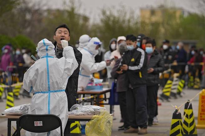 [베이징=AP/뉴시스] 중국 베이징의 코로나19 검사소에서 주민들이 코로나19 검사를 받고 있다. 코로나19 급증으로 봉쇄 중인 상하이는 사실상 무기한 전면 봉쇄에 들어갔다. 2022.04.06.