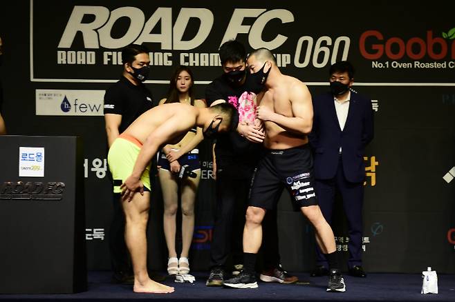 1차 계체량 측정에서 실패한 권아솔(왼쪽)이 남의철에게 사과하는 모습. 로드FC 제공