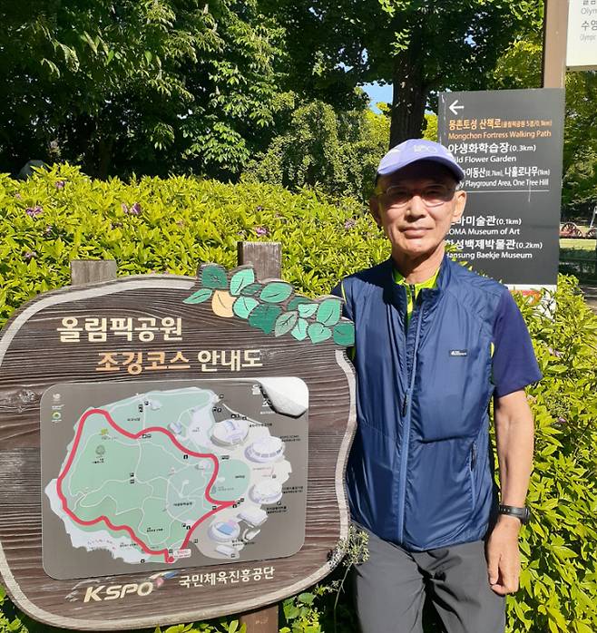 이경두 원장이 1990년 처음으로 달리기를 시작한 서울 올림픽 공원 산책로 표지판 옆에서 포즈를 취하고 있다. 김세훈 기자