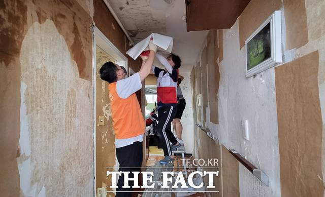 희망브리지 봉사단과 한화손해보험 직원 등 63명이 14일 부산시 해운대구의 재난위기가정을 찾아가 곰팡이가 핀 낡은 벽지와 장판을 걷어내고 도배와 바닥재 및 형광등을 교체하는 등 집수리 봉사를 펼쳤다. /희망브리지 제공
