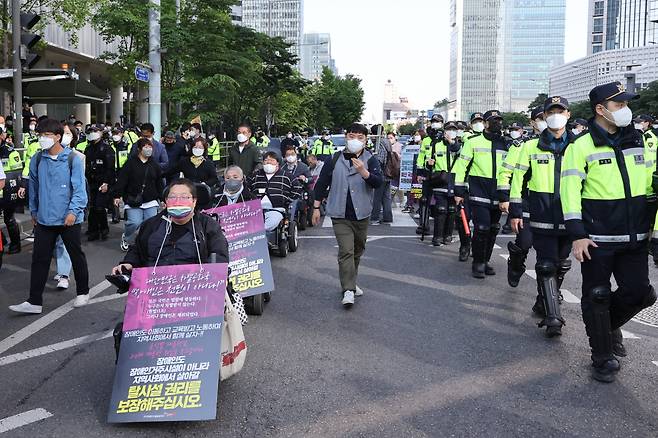 16일 오전 전국장애인차별철폐연대(전장연) 소속 장애인들이 장애인 권리 예산 보장을 요구하며 서울 용산구 신용산역에서 삼각지역 방향으로 행진하고 있다. [연합]