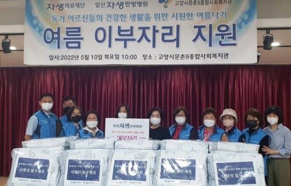 일산자생한방병원 임직원 및 일산자생봉사단이 독거 어르신들을 위한 혹서기 물품을 고양시문촌9종합사회복지관에 전달하며 기념 촬영을 하고 있다.