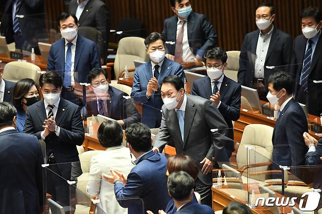 윤석열 대통령이 16일 국회 본회의장에서 코로나19 손실보상을 위한 추가경정예산(추경)안 시정연설을 하기 위해 입장하며 더불어민주당 소속 의원들과 인사를 나누고 있다. (대통령실사진기자단) 2022.5.16/뉴스1 © News1 오대일 기자