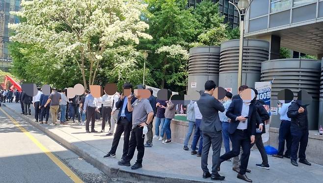 9일 오후 12시 서울 종로구 르메이에르종로타운 건물 뒤편 인도에서 40여명이 마스크를 내린 채 담배를 피우는 모습. / 이영관 기자