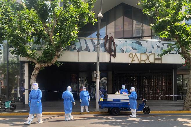 중국 상하이 거리에서 16일 방호복을 입은 의료진이 코로나19 이동 검사소를 운영하고 있다. 상하이시는 코로나19가 재확산하지 않으면 내달 1일부터 중하순까지 도시 봉쇄를 전면 해제할 예정이다. /AP 연합뉴스