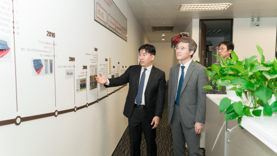 김희수(왼쪽) 오스템임플란트 광동법인장 상무이사가 한재혁 주광저우 총영사에게 기업 연혁을 설명하고 있다. 오스템임플란트 제공