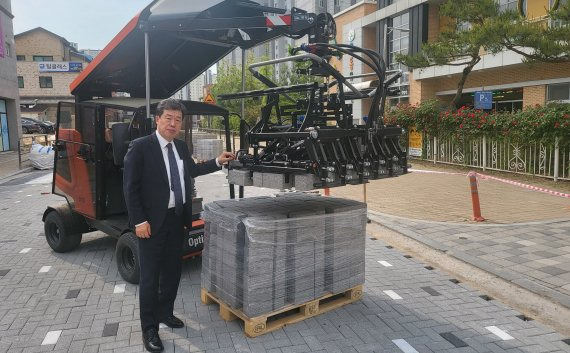 백원옥 대일텍 대표가 18일 투수블록 시공현장인 충북 진천군 덕산면 옥동초등학교 앞 도로에서 블록 시공 상황과 블록자동포장기계 등을 점검하고 있다.