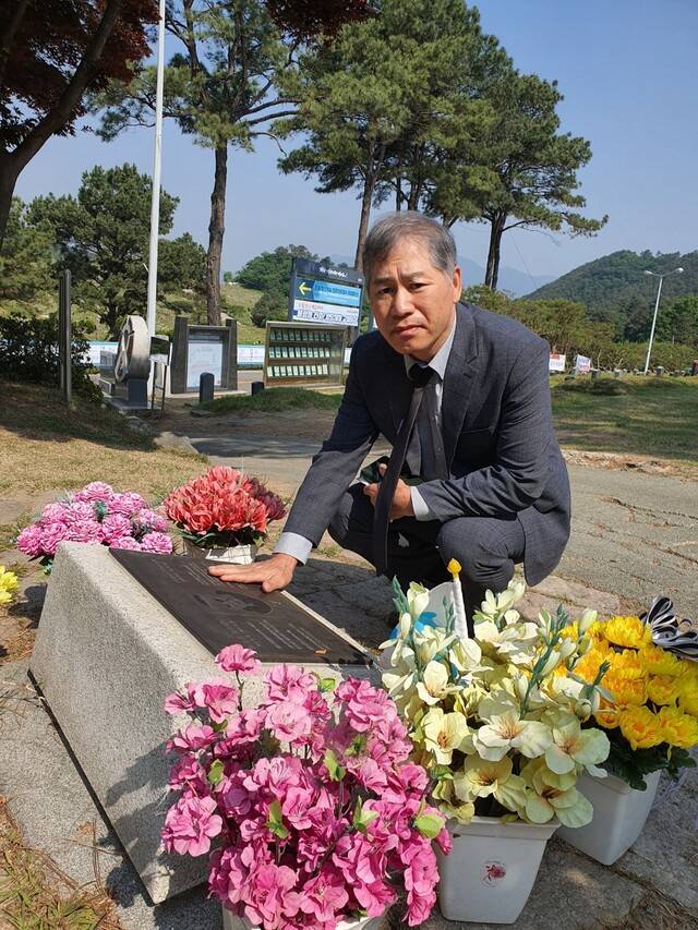 18일 아침 광주 망월동 5·18구묘역에 있는 독일 기자 고 위르겐 힌츠 페터 기념정원 앞에서 고인을 추모하고 있는 시민군 강철수씨. 정대하 기자