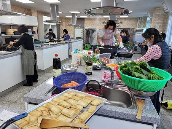 전라북도 남원시 여성새로일하기센터의 수료생들이 밑반찬 봉사활동을 위해 반찬만들기에 구슬땀을 흘리고 있다.[사진=남원시청]