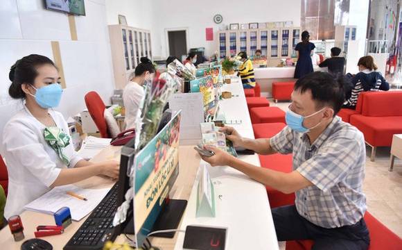 A customer makes a deposit at a bank in Bình Dương Province.