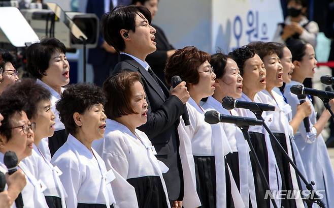 [광주=뉴시스] 신대희 기자 = 18일 오전 광주 북구 운정동 국립5·18민주묘지에서 5·18민주화운동 42주기 기념식이 열린 가운데 뮤지컬 배우 이지훈과 오월어머니 합창단이 합창을 하고 있다. (공동취재사진)  2022.05.18. sdhdream@newsis.com