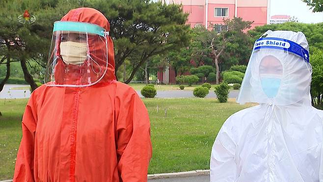 북한 방역요원(오른쪽)이 영문으로 ‘Face Shield’(안면보호구)라고 적힌 안면보호구를 착용하고 있다. 연합뉴스·조선중앙TV