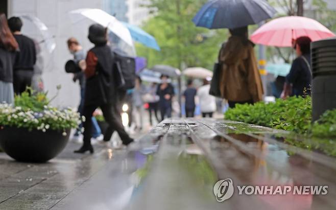 지난 18일 오전 서울 종로구 광화문역 인근에서 출근길 시민들이 우산을 쓰고 걸어가고 있다. [연합뉴스 자료사진]