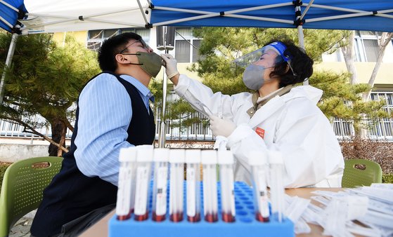 지난 3월 16일 서울 관악구 인헌중학교에서 한 학생이 코로나19대응 현장 이동형 PCR(유전자증폭) 검사를 받고 있다. [뉴스1]