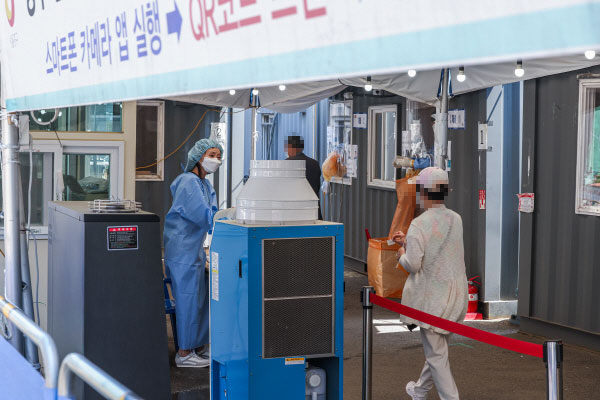지난 16일 오전 서울 중구 서울역 코로나19 선별검사소에서 시민이 PCR 검사를 받기 위해 안내를 받고 있다. [사진 출처 = 연합뉴스]