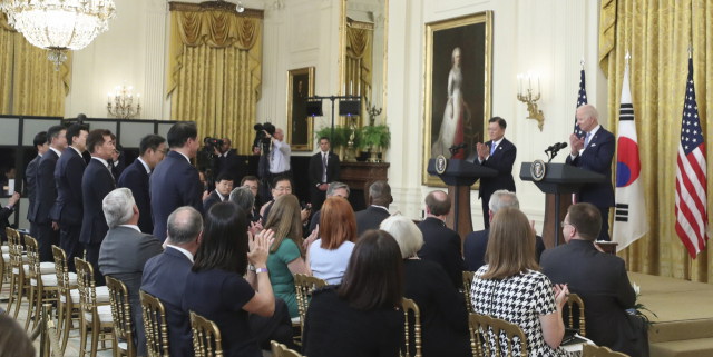 조 바이든 대통령이 지난해 5월 백악관에서 열린 한미정상회담 이후 우리 기업인들을 일으켜세워 박수를 치고 있다./연합뉴스