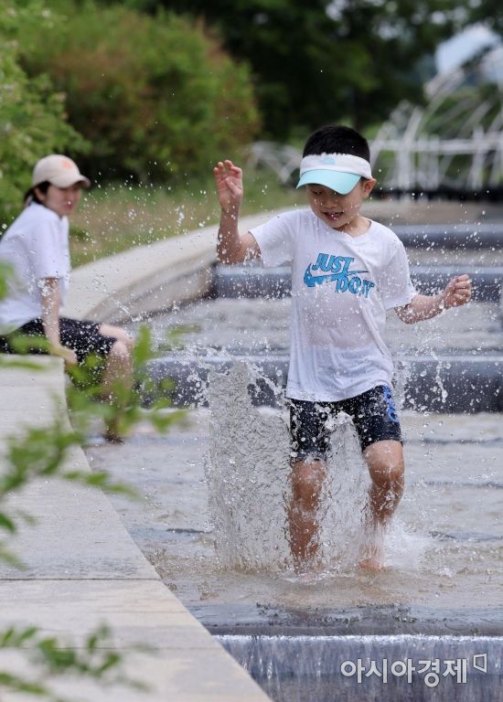 초여름 날씨를 보인 20일 서울 여의도한강공원에서 부모와 나들이를 나온 아이가 물놀이를 즐기고 있다./김현민 기자 kimhyun81@
