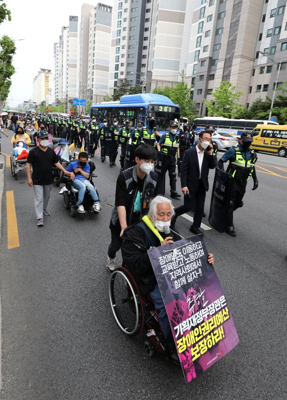 여야 서울시장 후보들은 이번 6·1 지방선거에서 장애인 시내버스 무료 공약을 내걸고 있다. 지난 19일 전국장애인차별철폐연대(전장연) 회원들이 장애인권리예산 추경반영 촉구 출근길 행진을 하고 있다. 뉴시스