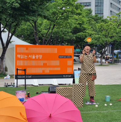 서울광장에 설치된 야외 도서관인 ‘책 읽는 서울광장’ 행사에 참여한 마술사가 지난 13일 공연을 펼치고 있다. 서울도서관 제공