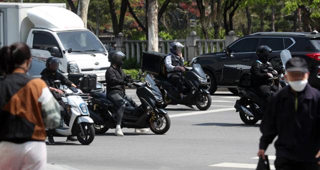 지난달 서울의 한 도로에서 오토바이 배달원들이 교통신호를 기다리고 있다. 뉴시스