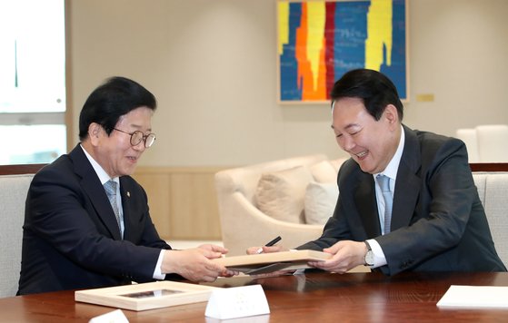 윤석열 대통령이 24일 용산 대통령실 청사 집무실에서 국회의장단을 접견하며 박병석 국회의장에게 바이든 미국 대통령과 함께 찍은 사진 액자를 선물하며 사인을 해주고 있다. 대통령실사진기자단