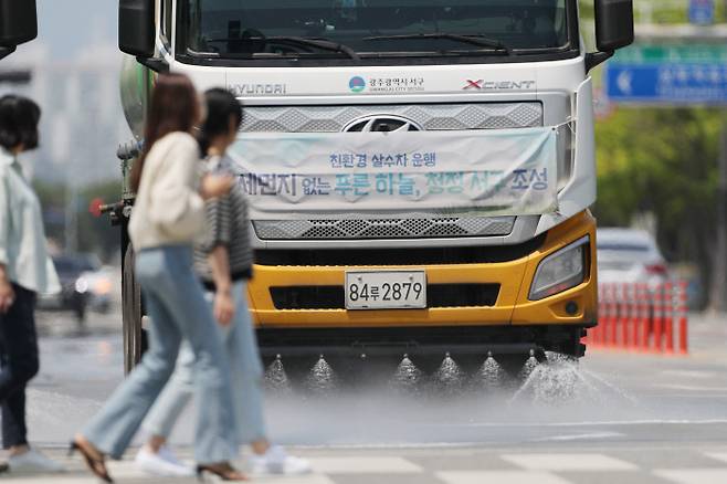 초여름 날씨를 보인 24일 오후 광주 서구 치평동 한 도로에서 폭염에 대비해 살수차가 시범운행 하고 있다. 연합뉴스