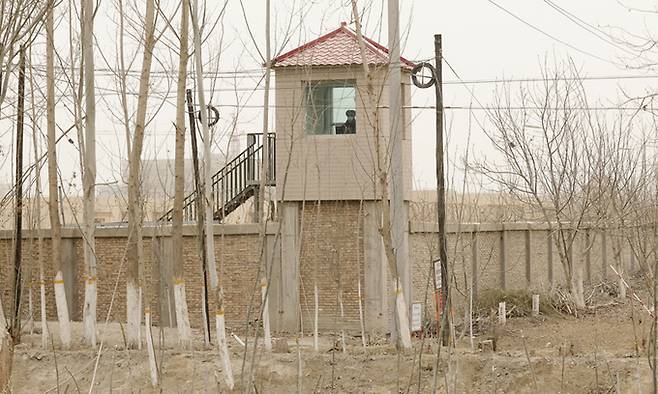 지난 21일 중국 신장위구르자치구 야켄트현의 한 구금시설 주변의 경비탑에서 보안요원이 지켜보고 있다. AP연합뉴스