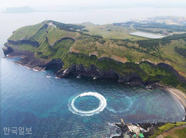 쇠머리오름 북측 검멀레해변에서 동굴투어 보트가 원을 그리며 스릴을 선사하고 있다.