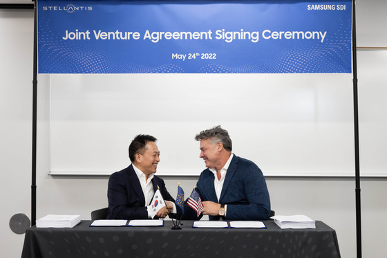 Choi Yoon-ho, left, CEO of Samsung SDI, and Mark Stewart, Stellantis chief operating officer for the North American region, shake hands after signing an agreement to invest $2.5 billion in building an EV battery factory in Kokomo, Indiana. [SAMSUNG SDI]