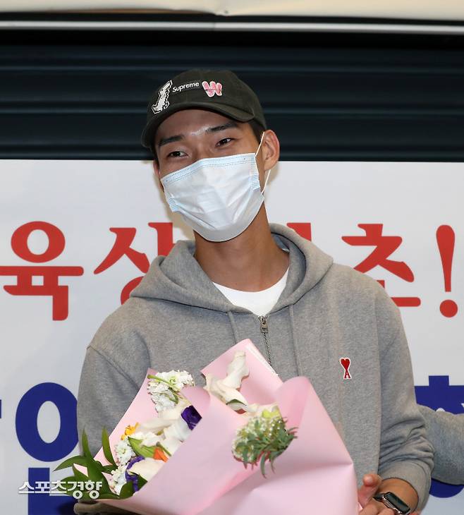 육상 다이아몬드리그에서 우승한 우상혁이 19일 인천공항으로 입국해 꽂다발을 받은 위 환하게 웃고 있다. 정지윤 선임기자
