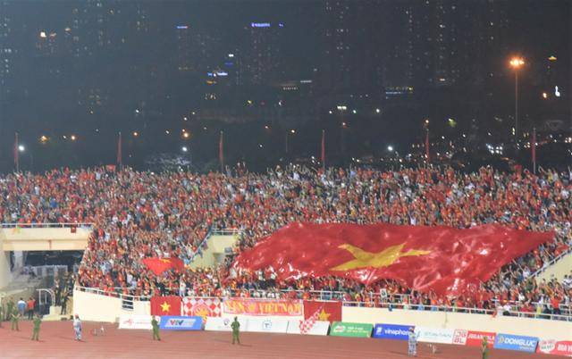 22일 베트남 하노이 미딩 국립경기장에서 열린 남자 축구 결승전에서 베트남의 쭝남만 선수가 결승골을 넣자 응원단이 대형 베트남 국기를 펼치며 환호하고 있다. 하노이=정재호 특파원