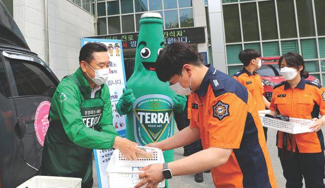 하이트진로 김인규 대표(맨 왼쪽)가 지난 13일 강릉소방서에서 열린 ‘2022 감사의 간식차’ 행사에서 소방관들에게 간식과 선물을 전달하고 있다.