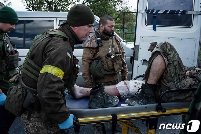 10일(현지시간) 우크라이나 리시칸스크 인근 도로에서 의무병이 러시아 군과 전투 중 부상을 당한 병사를 병원으로 후송하기 위해 차량에 싣고 있다. © AFP=뉴스1 © News1 우동명 기자